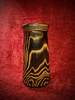 Vase en bois de frêne brulé. Ne tache pas au contact ! Contient une pièce en verre à l'intérieur qui se retire facilement. Diamètre du verre : 70 mm. Hauteur 17 cm. Origine du bois : Soulan (Ariège).